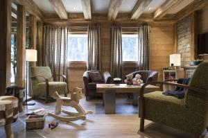 ein Wohnzimmer mit Stühlen und einem Tisch mit Spielzeug in der Unterkunft CGH Résidences & Spas Les Chalets d'Angèle in Châtel