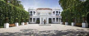 Une grande maison blanche avec une fontaine au milieu dans l'établissement Paradise Road Tintagel Colombo, à Colombo