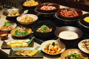 a table with many bowls of different types of food at hotel MONday KYOTO MARUTAMACHI in Kyoto