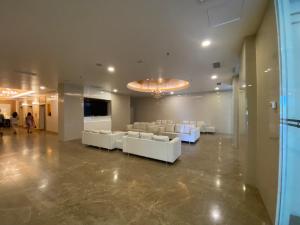 eine große Lobby mit weißen Sofas und einem TV in der Unterkunft A Modern & Homely Studio with Pool and Gym in Kampar