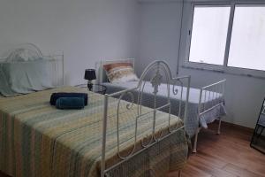 een slaapkamer met een bed, een stoel en ramen bij Villa T2 Maçussa - 45min Lisbon in Massuça