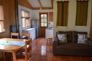 a living room with a couch and a table at Cabañas Valle del Río in Curacautín