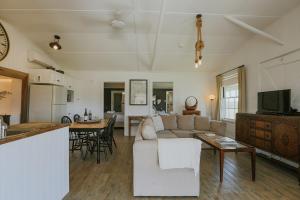 un soggiorno e una cucina con un divano e un tavolo di The Cooks House at Corunna Station a Belford