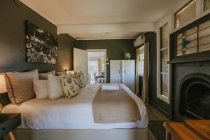 sypialnia z dużym łóżkiem i kominkiem w obiekcie The Cooks House at Corunna Station w mieście Belford
