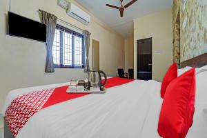 een slaapkamer met een groot bed met rode kussens bij Hotel Everest Grand in Coimbatore