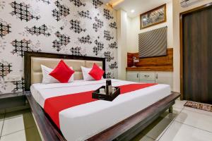 1 dormitorio con 1 cama grande con almohadas rojas en Super OYO Flagship Hotel Sky Land, en Ludhiana