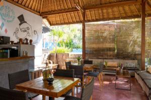 a restaurant with tables and chairs and a couch at Village Vibes Lombok in Kuta Lombok