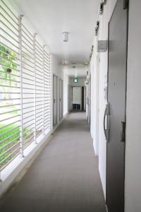 an empty hallway in an office building with windows at Maedamisaki Grand Blue 103 in Onna