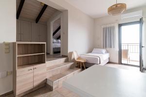 een slaapkamer met een bed en een bed en een raam bij Costa Mare in Paralia Vrachou