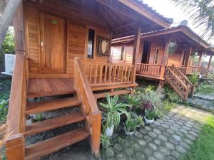 eine Holzhütte mit einer Treppe, die auf eine Veranda führt in der Unterkunft Pondok Elen Mandalika in Praya