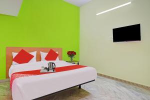 een slaapkamer met een bed met een groene muur bij Ss Delight in Hyderabad