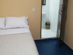 a bedroom with a bed and a mirror and a bathroom at Hotel Gavas Amazonas in Leticia