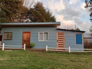 una casa azul con una valla delante de ella en CABAÑA OSORNO Ruta 215 en Osorno