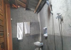 ein Badezimmer mit einem Waschbecken und einer Dusche mit Handtüchern in der Unterkunft Pondok Elen Mandalika in Praya