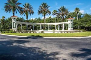 a white house with palm trees in a park at Be-Our-Guest Home! 15 mins to Disney! in Kissimmee