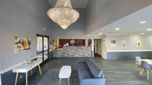 a waiting room with a couch and chairs and a chandelier at Days Inn & Suites by Wyndham Winnie in Winnie