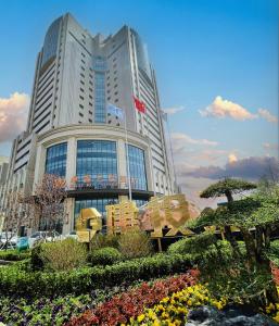 a tall building with a garden in front of it at Zhuo Ruiyunrui Hotel in Dongliucun