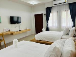 Habitación de hotel con 2 camas y TV de pantalla plana. en สราญรัตน์รีสอร์ท en Ban Noen Makok