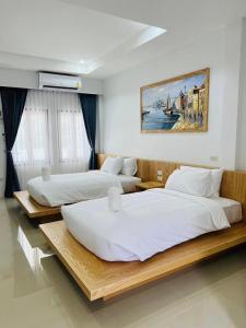 2 camas en una habitación de hotel con en สราญรัตน์รีสอร์ท en Ban Noen Makok