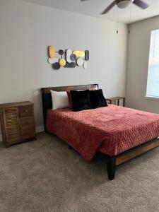 a bedroom with a bed with a red comforter at Stunning 2 bedroom Downtown Ft Worth in Fort Worth