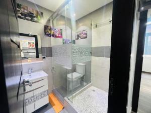a bathroom with a shower with a toilet and a sink at Calm Apartment in Mazola next to Aeria Mall & Casa Finance City in Casablanca