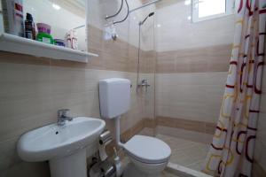 e bagno con servizi igienici, lavandino e doccia. di L&I Villa a Ulcinj