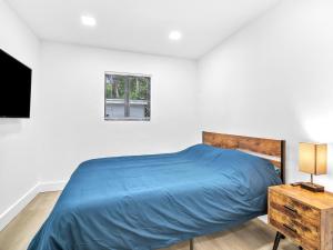 a bedroom with a blue bed and a window at Upscale 3 Bedroom House in Centric Location - in Miami Shores in Miami