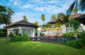 una casa con un patio con sillas y una piscina en The ShellSea Krabi I Luxury Beach Front Resort & Pool Villa, en Ao Nam Mao