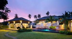 una casa con piscina frente a ella en The ShellSea Krabi I Luxury Beach Front Resort & Pool Villa en Ao Nam Mao