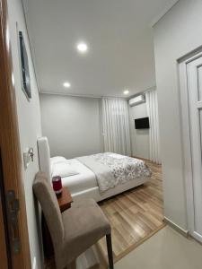 a small bedroom with a bed and a chair at L&I Villa in Ulcinj