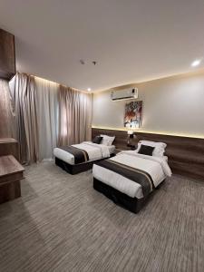 una habitación de hotel con 2 camas en una habitación en بارك المدينة للشقق المخدومة, en Medina