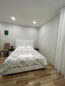 a bedroom with a white bed and a wooden floor at L&I Villa in Ulcinj