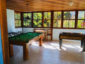 um quarto com duas mesas de bilhar e janelas em Pousada chalés Binitz em Viscode de Mauá
