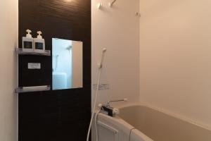 a bathroom with a sink and a tub and a mirror at 5963 Hotel Higashi Ikebukuro in Tokyo