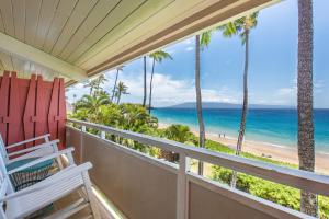 a balcony with a view of the beach and palm trees at Kaanapali Ocean Inn in Lahaina