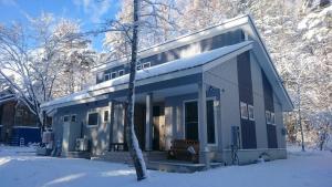 a small house in the snow in the woods at Avanti Chalet Hakuba by Jade Group in Hakuba