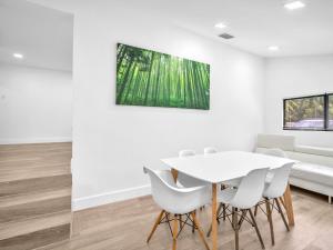 a dining room with a white table and white chairs at Upscale 3 Bedroom House in Centric Location - in Miami Shores in Miami