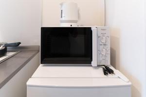 a microwave oven sitting on top of a refrigerator at 5963 Hotel Higashi Ikebukuro in Tokyo