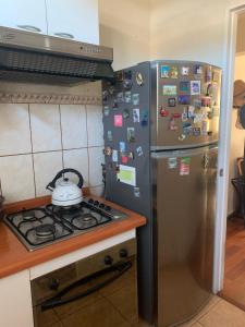 a kitchen with a stove and a refrigerator with magnets at Departamento de Lina in Valparaíso +8 photos