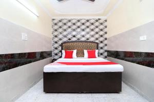 a bedroom with a bed with red pillows on it at Flagship Hotel New Diamond in Sohāna