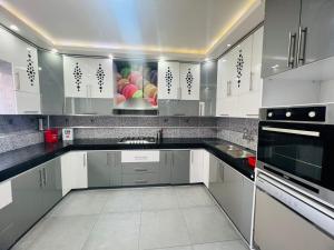 a kitchen with white cabinets and black counter tops at Calm Apartment in Mazola next to Aeria Mall & Casa Finance City in Casablanca