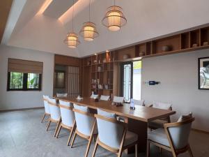 a large dining room with a long table and chairs at 岷江书院人文度假酒店 in Chengdu