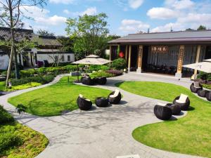 a patio with chairs and grass in front of a building at 岷江书院人文度假酒店 in Chengdu
