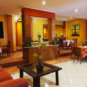 a lobby with a coffee table and a restaurant at Hotel Bristol Asuncion in Asuncion