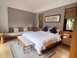 a bedroom with a large bed and a couch at 岷江书院人文度假酒店 in Chengdu +9 photos