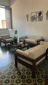 a living room with couches and tables in a room at HOTEL PLAZA BOLIVAR MOMPOX ubicado en el centro histórico con parqueadero interno in Mompos