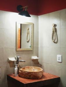 a bathroom with a stone sink and a mirror at Habitacion Roja / Casa del Café in Campeche