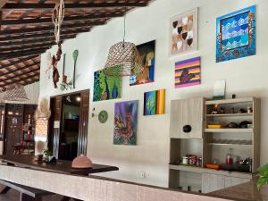 a kitchen with a counter with paintings on the wall at Vila Flexal Pousada I in Alter do Chao