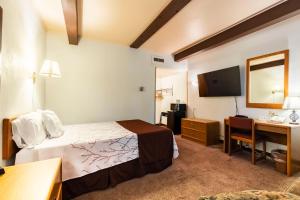 a hotel room with a bed and a desk at Aisling Suites - The Midtown in Great Falls