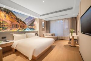 1 dormitorio con 1 cama blanca grande y TV en Atour X Hotel - Taikoo Li Chengdu, en Chengdú